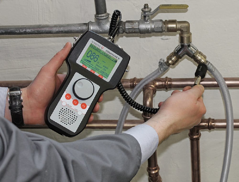 Plumber testing pipes with electronic leak detection equipment in Auburndale