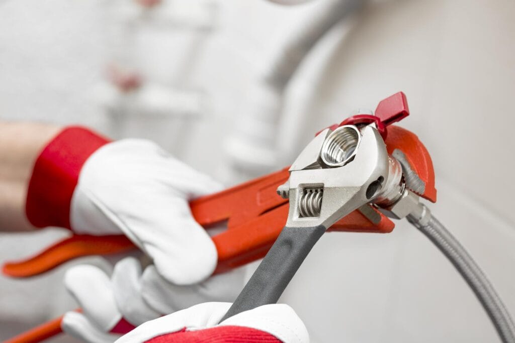Plumber holding pipe wrenches for an emergency repair in Auburndale