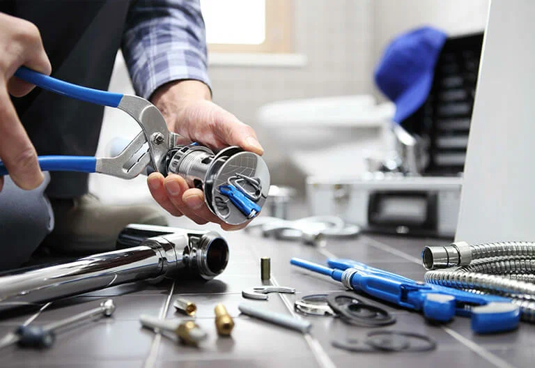 Technician repairing a plumbing fixture with professional tools in Auburndale