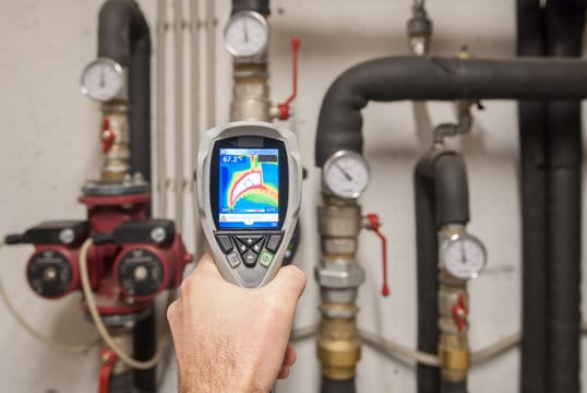 Plumber using a thermal imaging camera to inspect pipes in Auburndale
