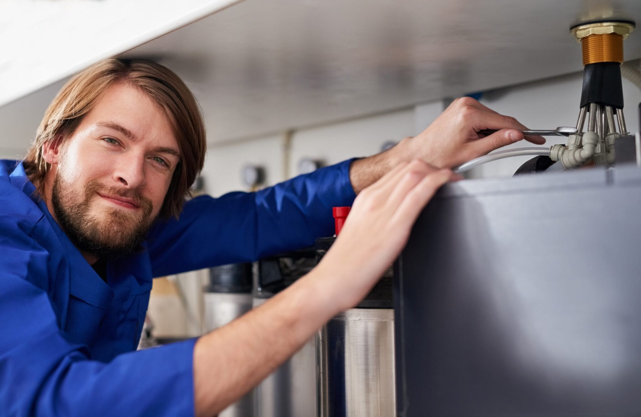 Technician servicing a residential water heater tank in Auburndale