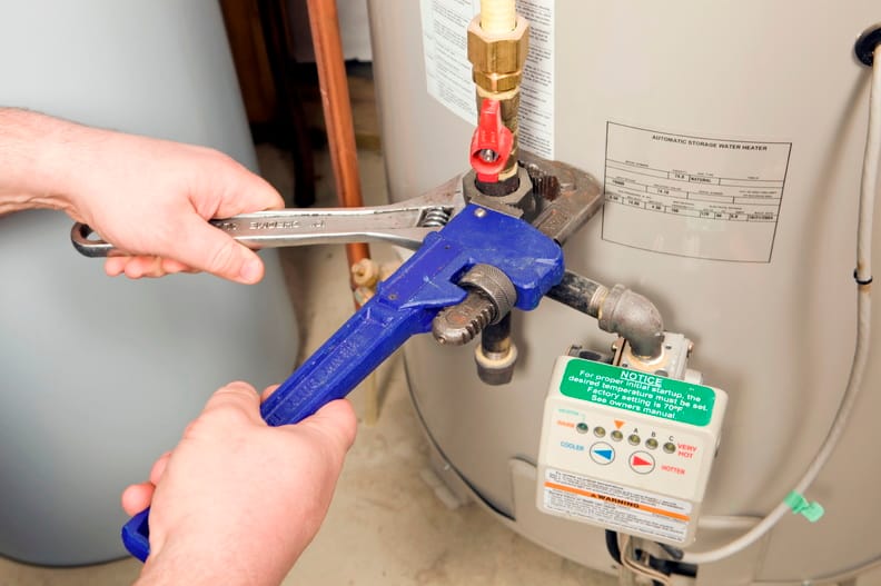 Plumber repairing a water heater valve in Auburndale